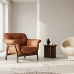 Deux fauteuils, l'un en cuir brun et l'autre en forme de coquille crème, placés dans un intérieur minimaliste épuré.